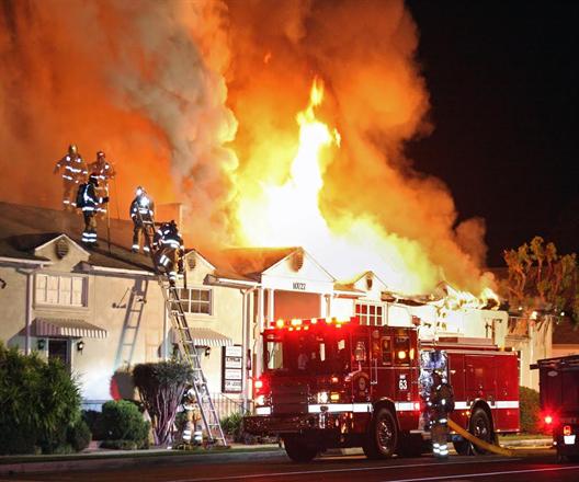 Firefighters on rooftop of flaming building