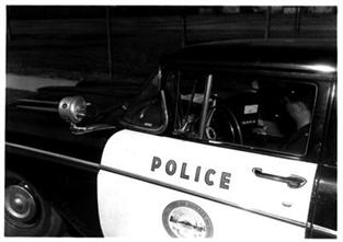 Black-and-white photo of an older police car